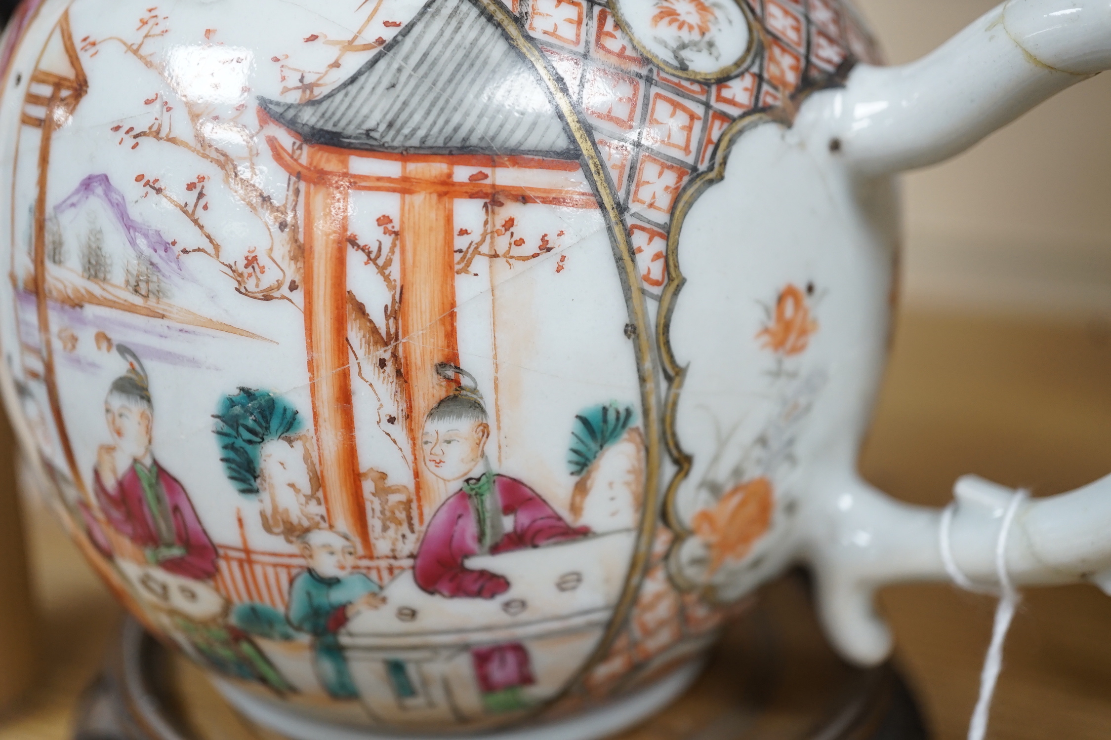 An 18th century Chinese export famille rose teapot with later silver spout and cover, on hardwood stand